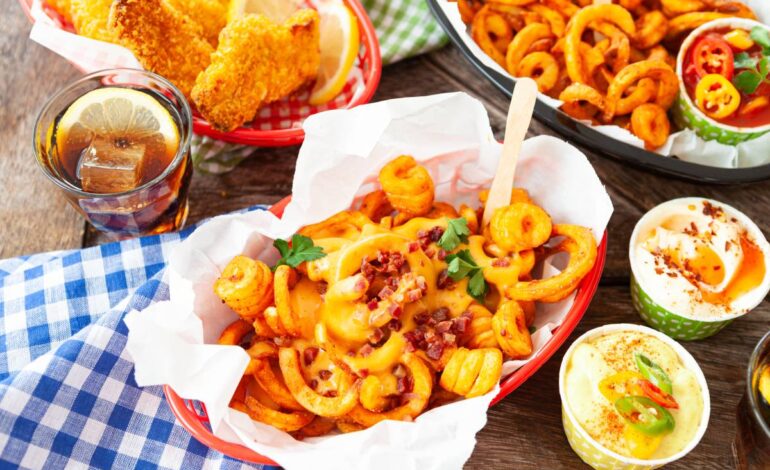 Tasty fast food with curly fries and fried chicken fingers